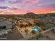 Aerial view of a desert home featuring a sparkling pool, backyard patio, desert landscaping, and solar panels at 10931 S Santa Columbia Dr, Goodyear, AZ 85338