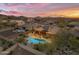 Aerial view of desert backyard featuring a swimming pool, desert landscaping, outdoor patio, and solar panels at 10931 S Santa Columbia Dr, Goodyear, AZ 85338