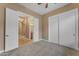 Bedroom with carpet flooring, closet with sliding doors, and en-suite bathroom access at 10931 S Santa Columbia Dr, Goodyear, AZ 85338