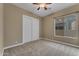 Bedroom with carpet, a ceiling fan, closet with sliding doors, and large window at 10931 S Santa Columbia Dr, Goodyear, AZ 85338