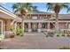 Beautiful community clubhouse entrance with brick facade, covered walkway, and manicured landscaping at 10931 S Santa Columbia Dr, Goodyear, AZ 85338