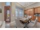 Dining area featuring a rustic wood table, upholstered chairs, ample storage cabinetry, and a modern chandelier at 10931 S Santa Columbia Dr, Goodyear, AZ 85338
