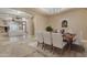 Formal dining room featuring a table set for six with an elegant chandelier overhead and view to the living room at 10931 S Santa Columbia Dr, Goodyear, AZ 85338