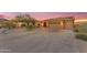 Beautiful desert home with a spacious driveway and two-car garage is set against a colorful sunset backdrop at 10931 S Santa Columbia Dr, Goodyear, AZ 85338