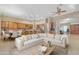 Spacious living room offering an open layout to the kitchen, a comfortable sectional sofa, and a ceiling fan at 10931 S Santa Columbia Dr, Goodyear, AZ 85338