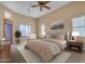 Main bedroom with carpet, natural light, ceiling fan, and neutral tones creating a warm and inviting space at 10931 S Santa Columbia Dr, Goodyear, AZ 85338