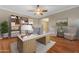 Home office showcasing a large desk, built-in shelving, hardwood floors, a ceiling fan, and a comfortable seating area at 10931 S Santa Columbia Dr, Goodyear, AZ 85338