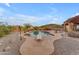 Spacious backyard featuring a freeform pool, diving board, desert landscaping, and mountain views at 10931 S Santa Columbia Dr, Goodyear, AZ 85338
