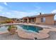 Dream backyard showcasing a vast freeform pool, diving board, mature desert plants, and mountain views at 10931 S Santa Columbia Dr, Goodyear, AZ 85338