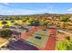 Aerial view of tennis courts surrounded by lush greenery and homes at 10931 S Santa Columbia Dr, Goodyear, AZ 85338