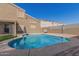 A private backyard pool shimmers under a clear blue sky, surrounded by a fenced yard with neighboring houses at 12725 W Boca Raton Rd, El Mirage, AZ 85335