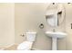 Compact powder room featuring a pedestal sink, toilet, and neutral wall color at 12725 W Boca Raton Rd, El Mirage, AZ 85335