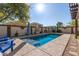 Sparkling pool in a backyard oasis with blue patio furniture, plants, and block wall fencing at 1297 E Maddison St, San Tan Valley, AZ 85140