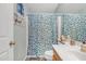 A well-lit bathroom features a blue-patterned shower curtain, a white sink, and neutral-colored walls at 1313 E Tyson St, Chandler, AZ 85225