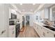 Modern white kitchen with stainless steel appliances, updated cabinets and flooring at 14633 N Boswell Blvd, Sun City, AZ 85351