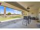 Covered patio with outdoor seating, offering a relaxing space with views of the landscaped backyard at 14633 N Boswell Blvd, Sun City, AZ 85351