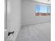 A clean, carpeted bedroom interior with a bright window, offering a simple aesthetic at 14777 W Soft Wind Dr, Surprise, AZ 85387
