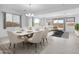 Elegant dining area flows into the living room with sleek furniture and large windows at 14777 W Soft Wind Dr, Surprise, AZ 85387