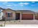Inviting single-story home featuring desert landscaping, a brick-accented facade, and a brick paver driveway at 14777 W Soft Wind Dr, Surprise, AZ 85387