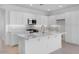 Well-lit kitchen featuring white cabinets, stainless steel appliances, a center island, and modern backsplash at 14777 W Soft Wind Dr, Surprise, AZ 85387