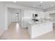 Bright, modern kitchen with white cabinets, stainless steel appliances, and an island open to the living area at 14777 W Soft Wind Dr, Surprise, AZ 85387