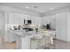 Bright kitchen with white cabinets, stainless steel appliances, quartz counters, and a spacious center island with bar seating at 14777 W Soft Wind Dr, Surprise, AZ 85387