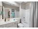 Well-lit bathroom with a vanity, toilet, bathtub and shower featuring a silver shower curtain at 1589 E Manor Dr, Casa Grande, AZ 85122