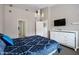 Comfortable bedroom showcasing neutral walls, chandelier, television, and a bed with blue patterned bedding at 1589 E Manor Dr, Casa Grande, AZ 85122