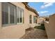 Tan home exterior showing window shutters, gravel landscaping and synthetic grass at 1589 E Manor Dr, Casa Grande, AZ 85122