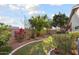 Private backyard featuring mature trees, flower beds, and a well-maintained lawn at 15911 W Carmen Dr, Surprise, AZ 85374
