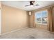 Cozy bedroom with a ceiling fan and natural light streaming through the window at 15911 W Carmen Dr, Surprise, AZ 85374
