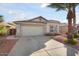 Charming single-story home with a two-car garage, desert landscaping, and a mature palm tree at 15911 W Carmen Dr, Surprise, AZ 85374