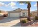 Charming single-story home with a two-car garage, desert landscaping, and a mature palm tree at 15911 W Carmen Dr, Surprise, AZ 85374
