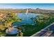 Picturesque aerial view of a lake with a fountain, surrounded by lush landscaping and mountains at 16545 E Gunsight Dr # 103, Fountain Hills, AZ 85268