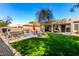 Expansive backyard including a spa, outdoor kitchen, and covered patio area at 18053 W Banff Ln, Surprise, AZ 85388