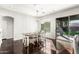 Bright dining room with a modern chandelier, hardwood floors, and a sliding glass door to the backyard at 18053 W Banff Ln, Surprise, AZ 85388