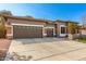 Spacious single-story home with a three-car garage, ample driveway space, and desert landscaping at 18053 W Banff Ln, Surprise, AZ 85388