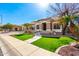 Beautiful single-story home featuring desert landscaping, green turf, and attractive stonework on the facade at 18053 W Banff Ln, Surprise, AZ 85388