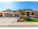 Charming single-story home featuring a three-car garage, stone accents, desert landscaping and a manicured lawn at 18053 W Banff Ln, Surprise, AZ 85388