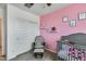 Charming Bedroom with pink accent wall, gray crib, and cozy rocking chair at 20236 W Madison St, Buckeye, AZ 85396