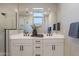 Bathroom with double sinks, white cabinets, framed mirrors, and a glass-enclosed shower at 2121 W Sonoran Desert Dr # 45, Phoenix, AZ 85085