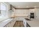 Bright kitchen features white cabinets, stainless appliances, large island and hardwood flooring at 2121 W Sonoran Desert Dr # 45, Phoenix, AZ 85085