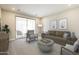 Well-lit living room features neutral paint, carpet, modern furniture and a sliding glass door to the balcony at 2121 W Sonoran Desert Dr # 45, Phoenix, AZ 85085
