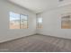 Bedroom features neutral carpet, three windows, and white walls at 21640 E Roundup Way, Queen Creek, AZ 85142