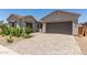 Stunning front exterior with a well-manicured yard and paved driveway leading to two garages at 21640 E Roundup Way, Queen Creek, AZ 85142