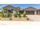 Charming single-story home featuring a well-manicured yard, desert landscaping, and a two-car garage at 21640 E Roundup Way, Queen Creek, AZ 85142