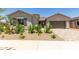 Charming single-story home with desert landscaping and a paver driveway leading to the garage at 21640 E Roundup Way, Queen Creek, AZ 85142