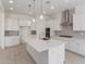 Bright kitchen features a large island, white cabinets, stainless steel appliances, and stylish pendant lighting at 21640 E Roundup Way, Queen Creek, AZ 85142