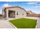 This backyard features a covered patio and artificial grass surrounded by gravel at 2235 W Park St, Phoenix, AZ 85041