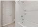 A full bathroom with a white tiled shower-bath combo and a white door at 2235 W Park St, Phoenix, AZ 85041